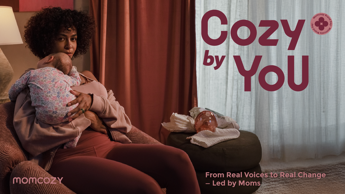 Woman holding a baby on a couch with 'Cozy by You' branding in the background.
